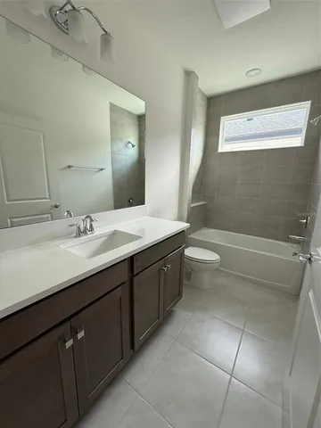 a spacious bathroom with a granite countertop sink a toilet and a bathtub
