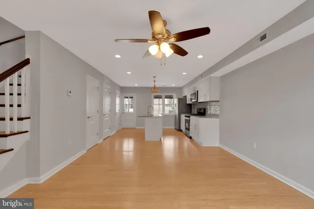 a view of an empty room and kitchen view