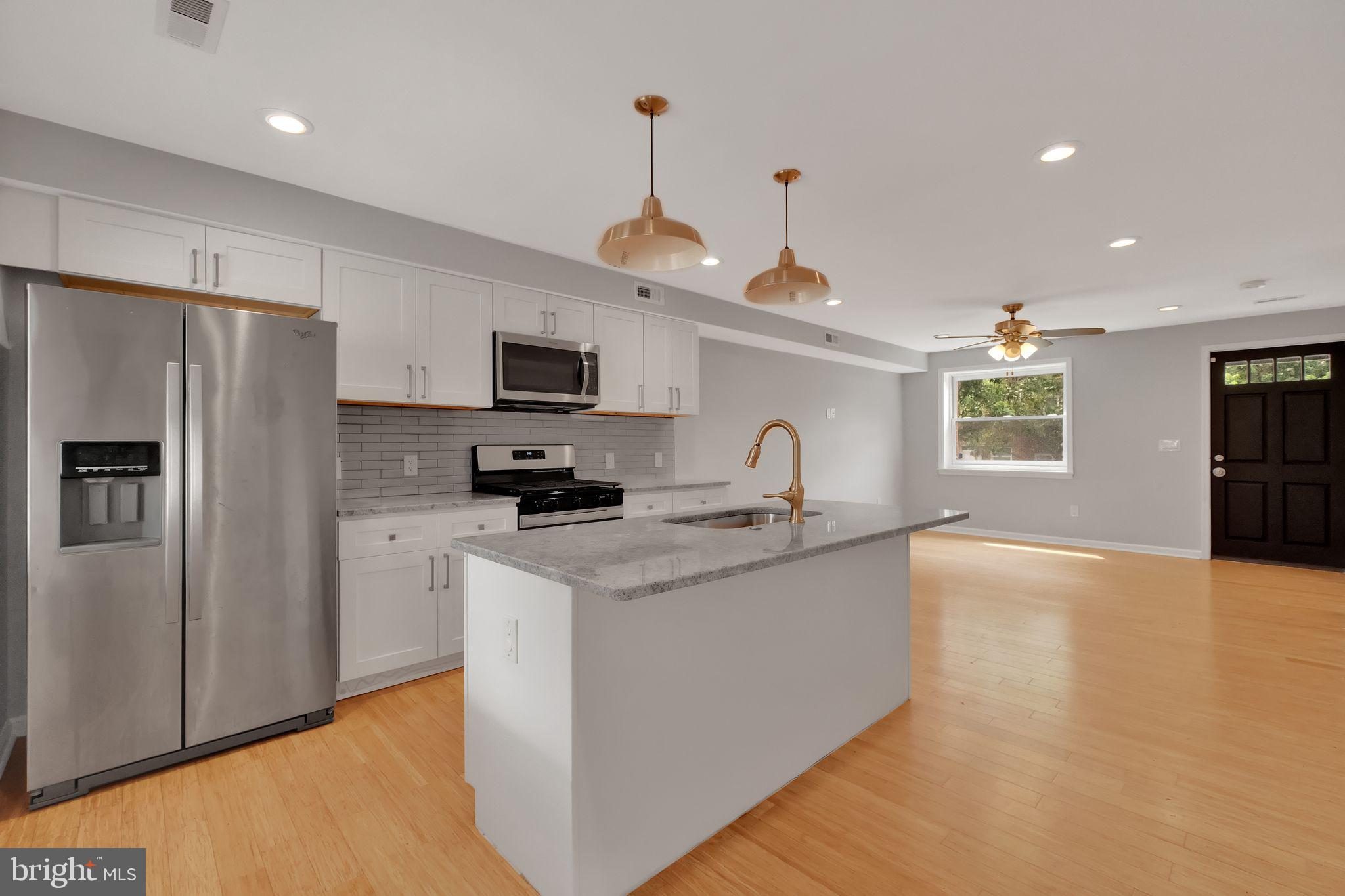 245 South Clinton Street Baltimore, MD 21224 - Photo 8 of 39 a kitchen with stainless steel appliances granite countertop a sink stove and refrigerator