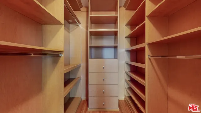 a view of walk in closet with empty racks