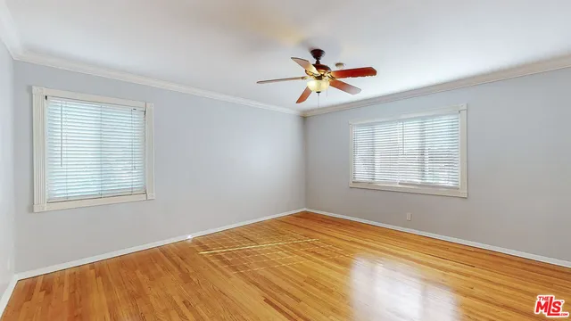 a bedroom with a window and a ceiling fan