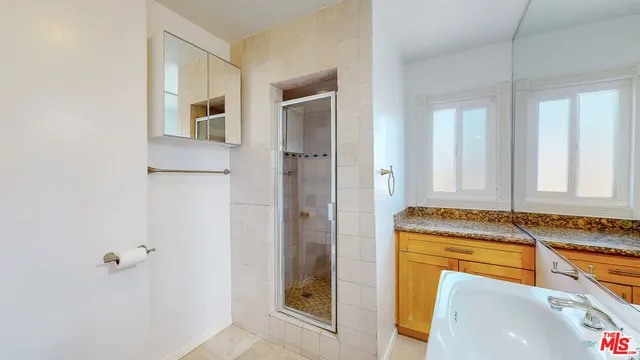 a bathroom with a granite countertop sink and a mirror