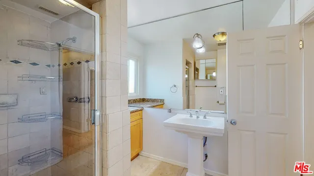 a bathroom with a double vanity sink mirror and shower