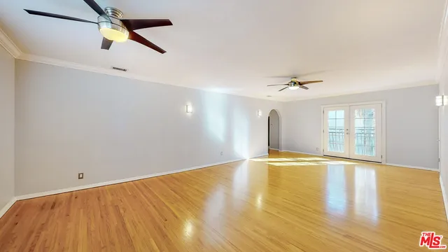a view of an empty room with window and wooden floor