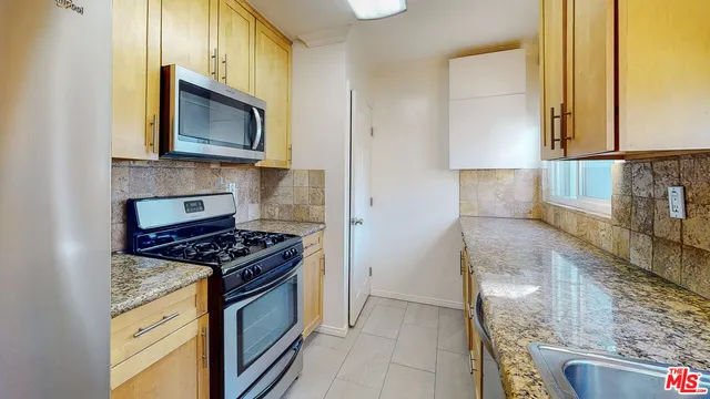 a kitchen with stainless steel appliances granite countertop a stove and a microwave