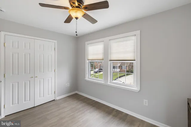 an empty room with windows and fan