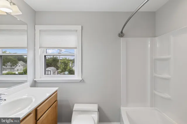 a bathroom with a sink toilet and window