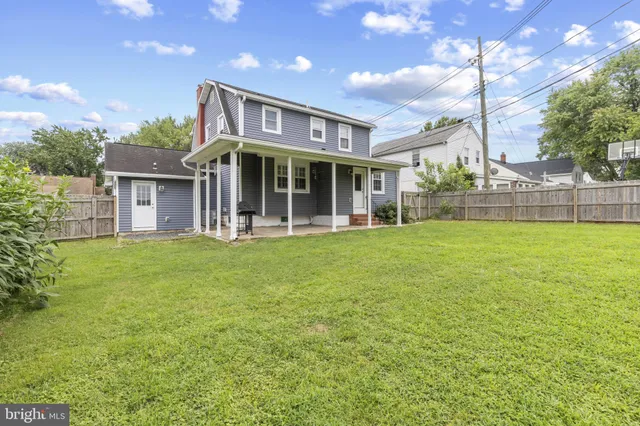a view of a house with a big yard and large trees