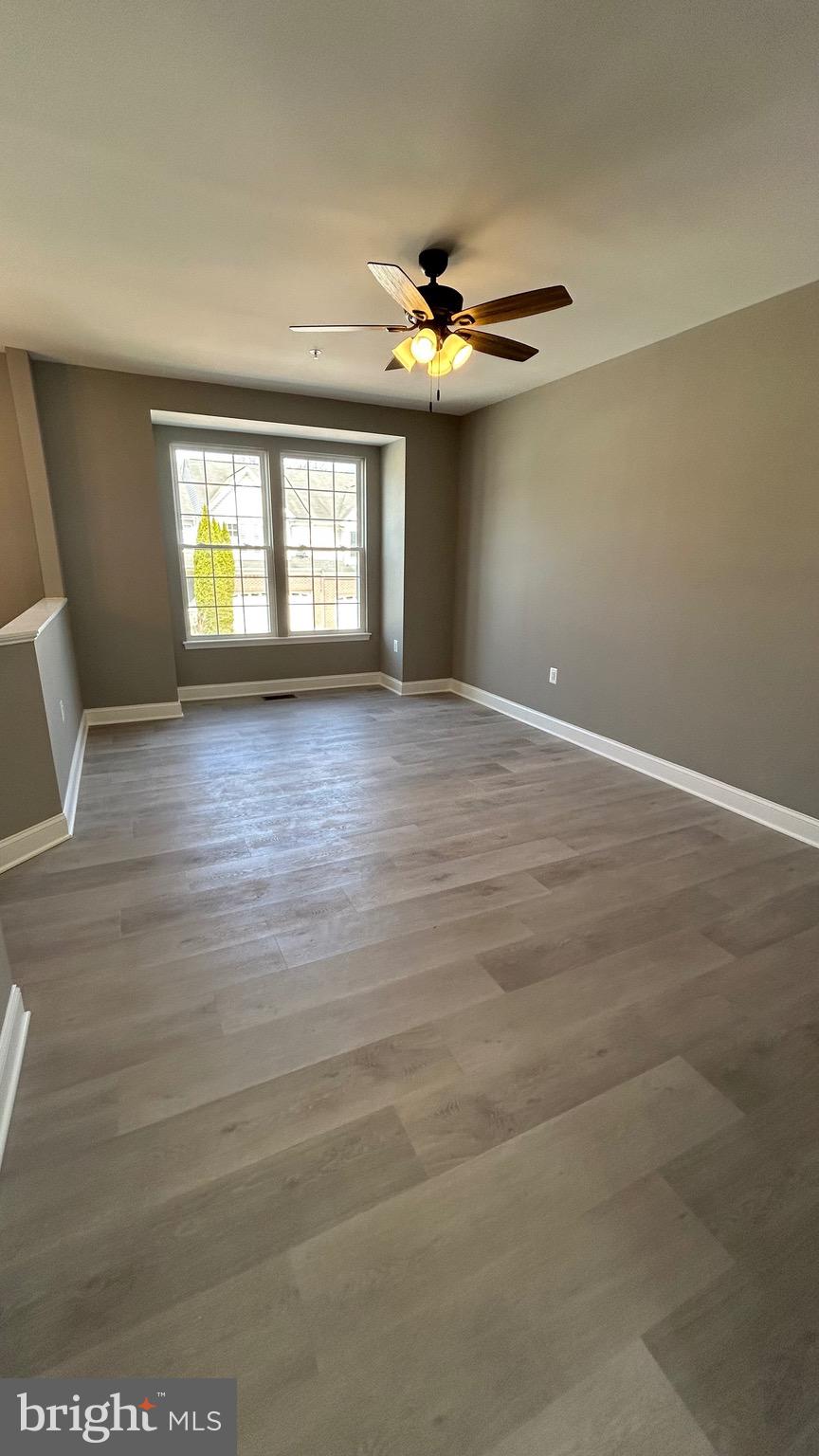 4739 Witchhazel Way Aberdeen, MD 21001 - Photo 8 of 32 an empty room with wooden floor chandelier fan and windows