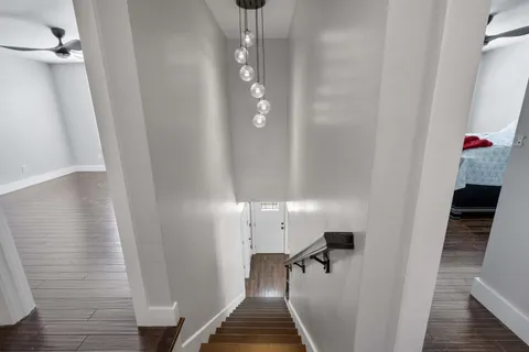 a view of a hallway with wooden floor and staircase