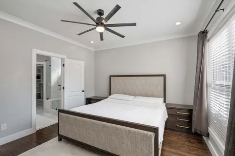 a bedroom with a large bed and a chandelier