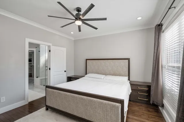 a bedroom with a large bed and a chandelier