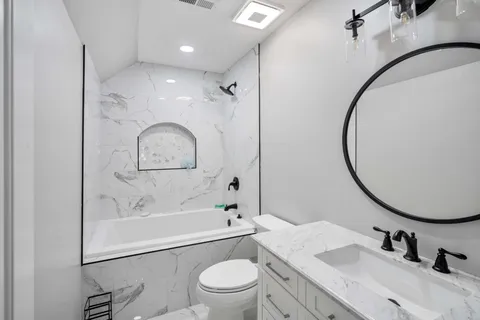 a bathroom with a sink a toilet and a mirror