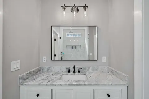 a bathroom with a granite countertop sink and a mirror