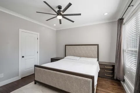 a bedroom with a large bed and a ceiling fan