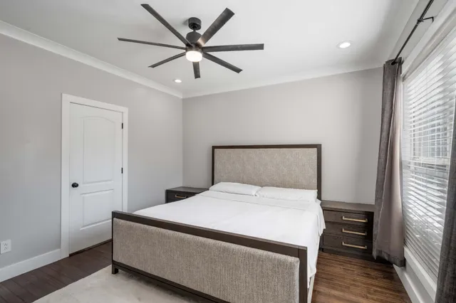 a bedroom with a large bed and a ceiling fan