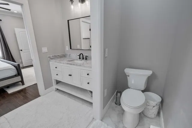 a bathroom with a toilet sink and mirror