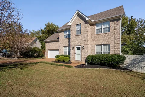 a front view of a house with a yard and a garage