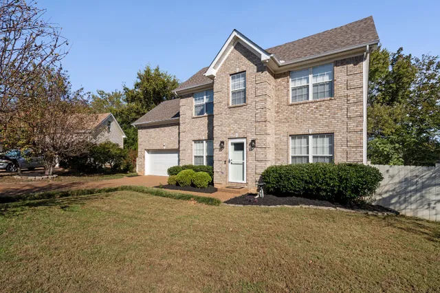 a front view of a house with a yard and a garage