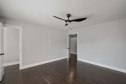 a view of a room with wooden floor and ceiling fan