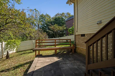 a green bench sitting in back yard of a house