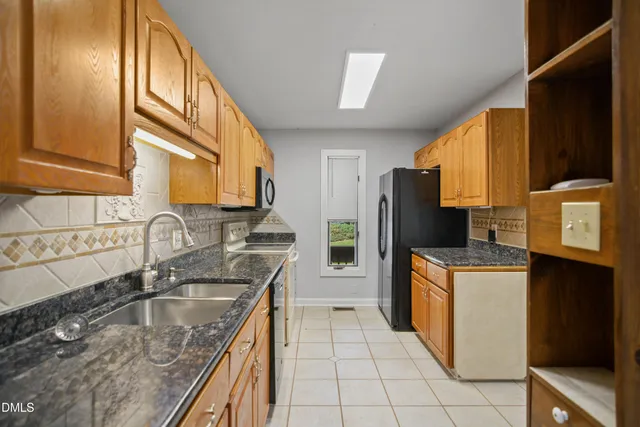 a kitchen with a sink stove top oven and refrigerator