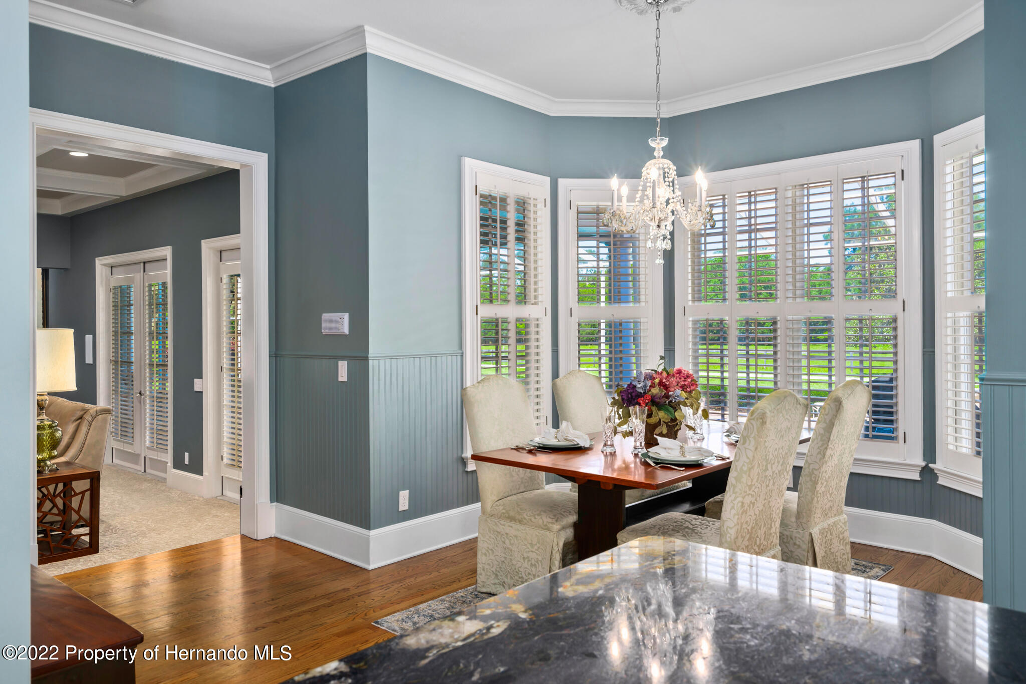 21411 Brookes Run Road Brooksville, FL 34602 - Photo 15 of 62 a dining room with furniture large windows and wooden floor