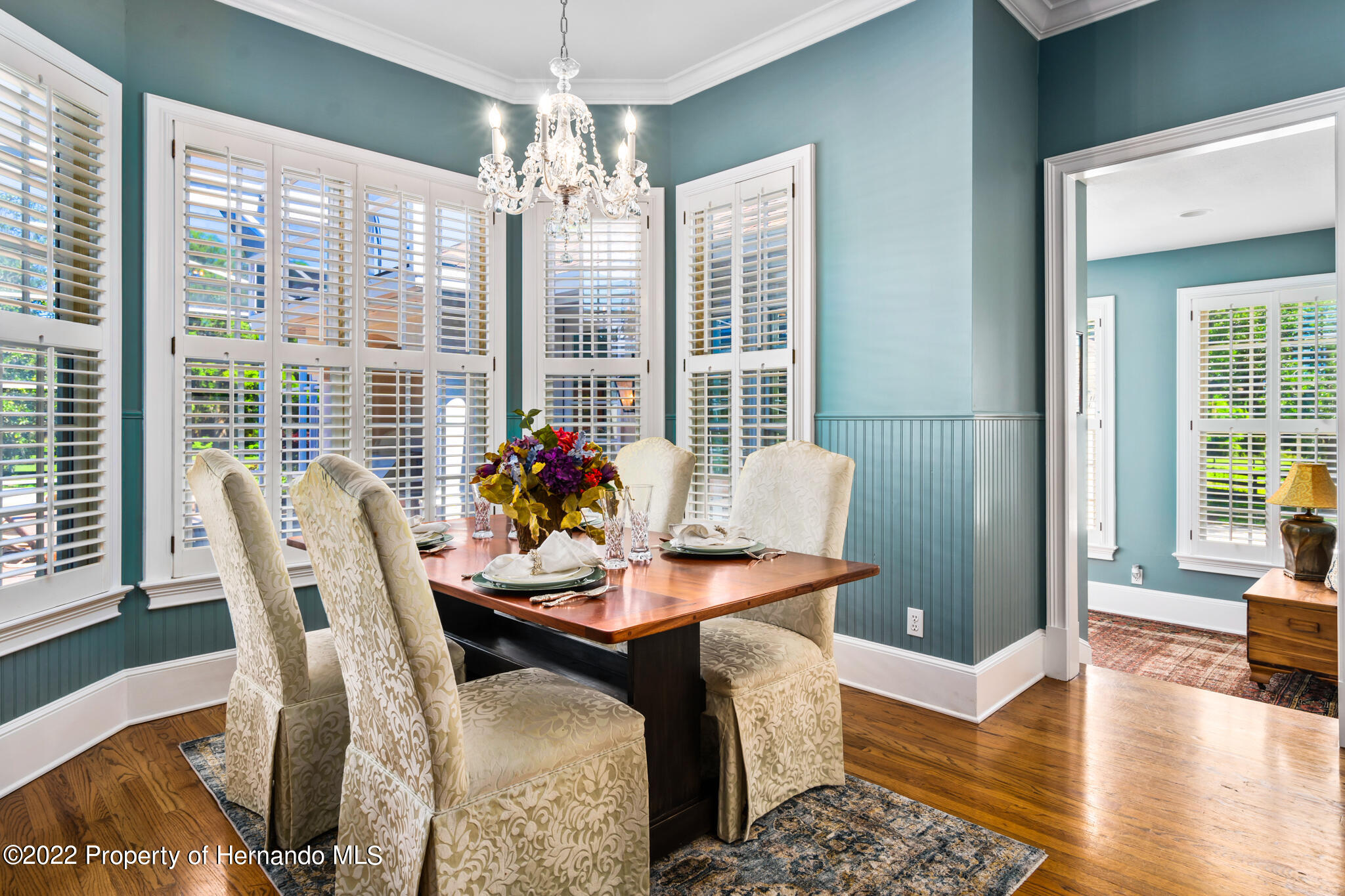 21411 Brookes Run Road Brooksville, FL 34602 - Photo 17 of 62 a dining room with furniture a chandelier and wooden floor