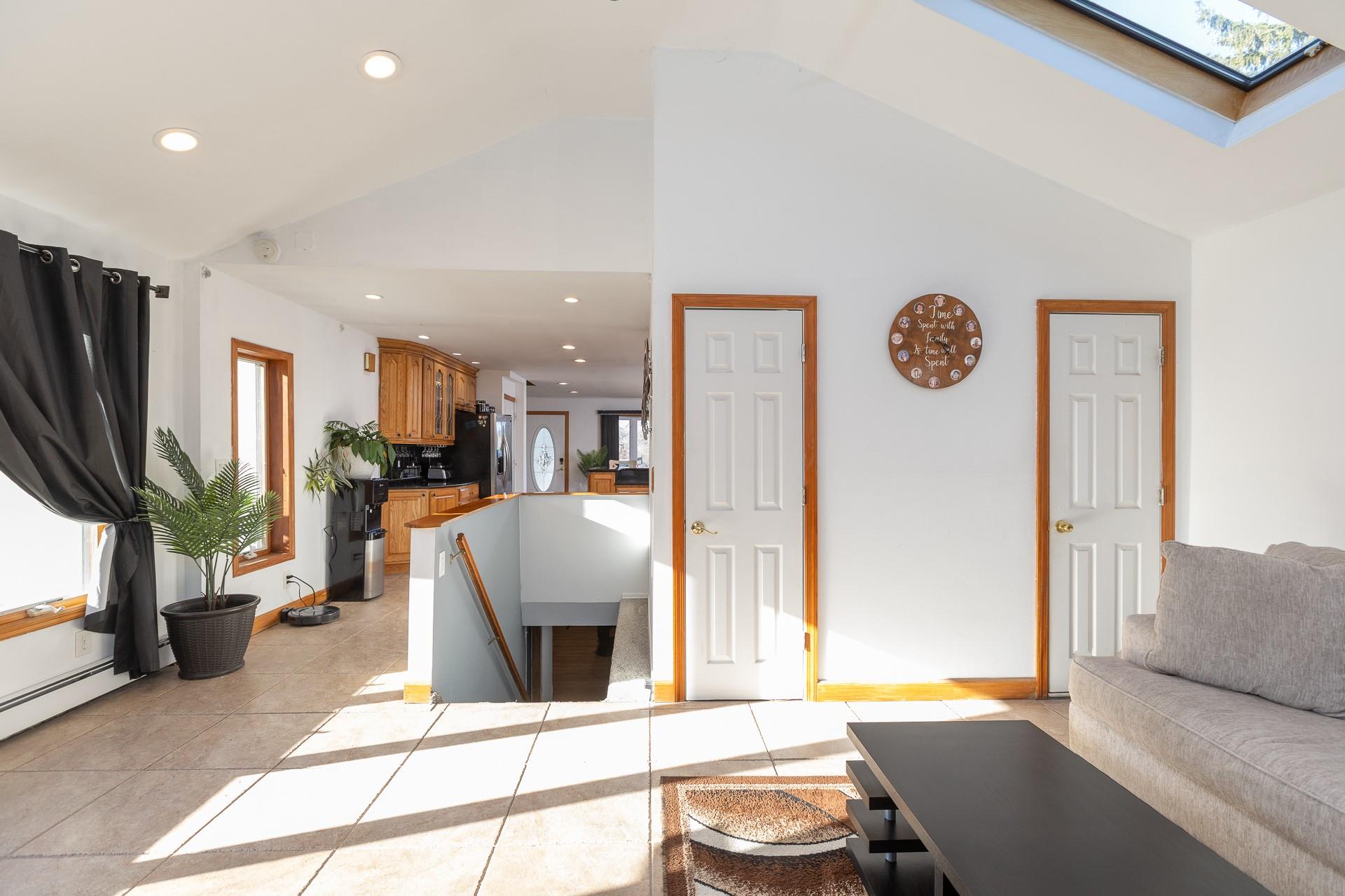 84 Riverside Avenue Mastic Beach, NY 11951 - Photo 12 of 32 Living area with light tile patterned flooring, a healthy amount of sunlight, recessed lighting, and a skylight