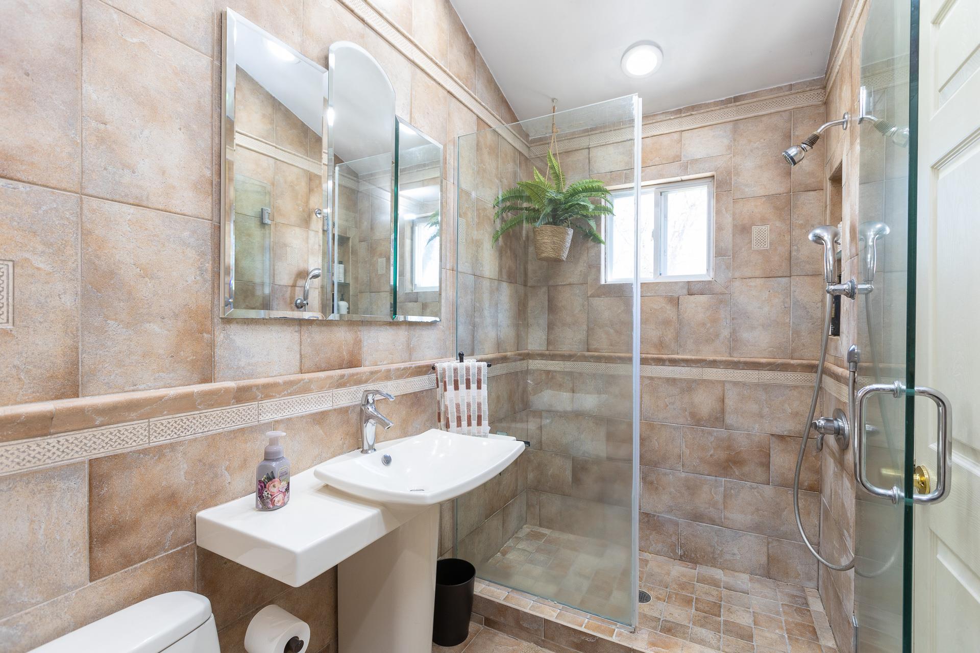 84 Riverside Avenue Mastic Beach, NY 11951 - Photo 15 of 32 Full bath featuring backsplash, toilet, a stall shower, and tile walls