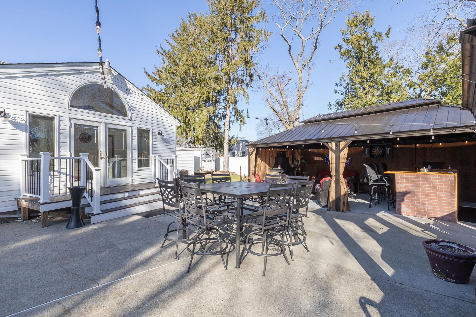 84 Riverside Avenue Mastic Beach, NY 11951 - Photo 22 of 32 View of patio / terrace with fence, outdoor dining space, and outdoor dry bar