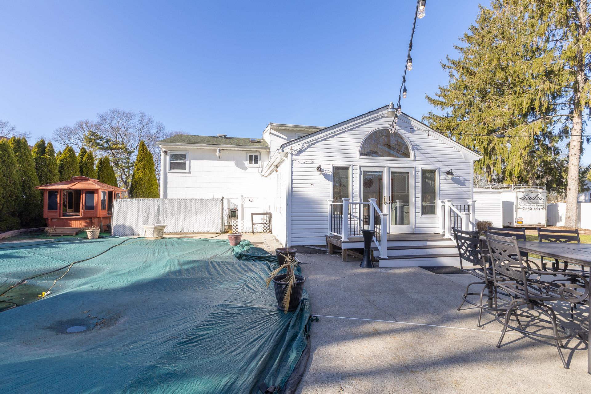 84 Riverside Avenue Mastic Beach, NY 11951 - Photo 27 of 32 Rear view of house featuring fence, outdoor dining area, a fenced in pool, and a patio area