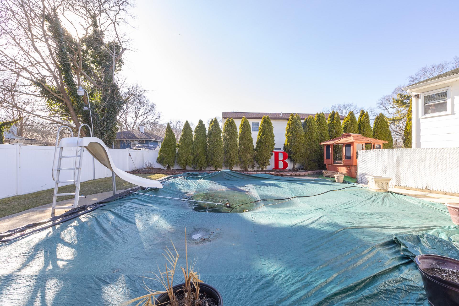 84 Riverside Avenue Mastic Beach, NY 11951 - Photo 28 of 32 View of pool featuring a fenced backyard, a water slide, and a fenced in pool