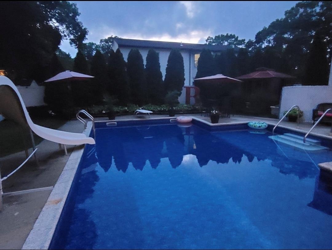 84 Riverside Avenue Mastic Beach, NY 11951 - Photo 29 of 32 Outdoor pool featuring a water slide, a patio area, and a diving board