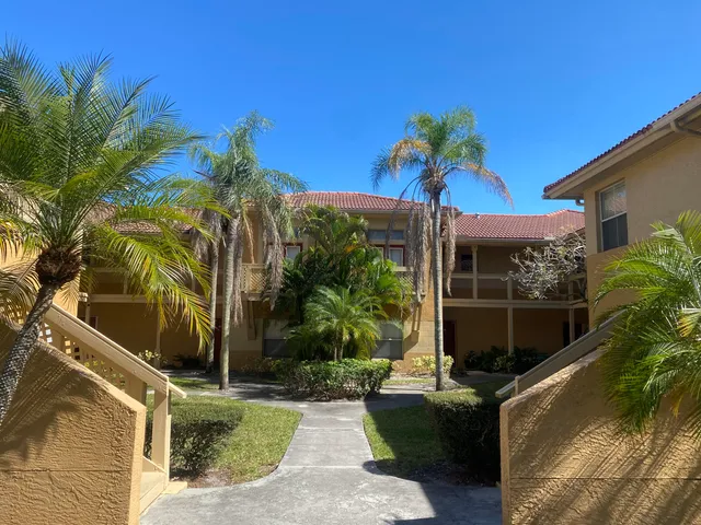 a backyard of a house with table and chairs potted plants