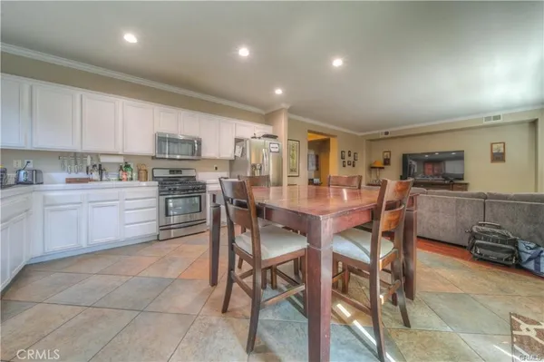 a kitchen with kitchen island a dining table and chairs