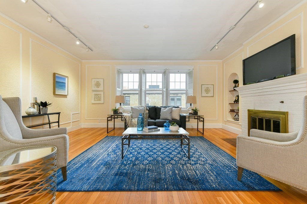411 Washington Street, Unit 6 Brookline, MA 02446 - Photo 1 of 32 a living room with furniture a flat screen tv and a fireplace