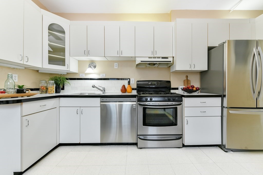 411 Washington Street, Unit 6 Brookline, MA 02446 - Photo 11 of 32 a kitchen with stainless steel appliances granite countertop white cabinets a refrigerator a stove a sink and white cabinets
