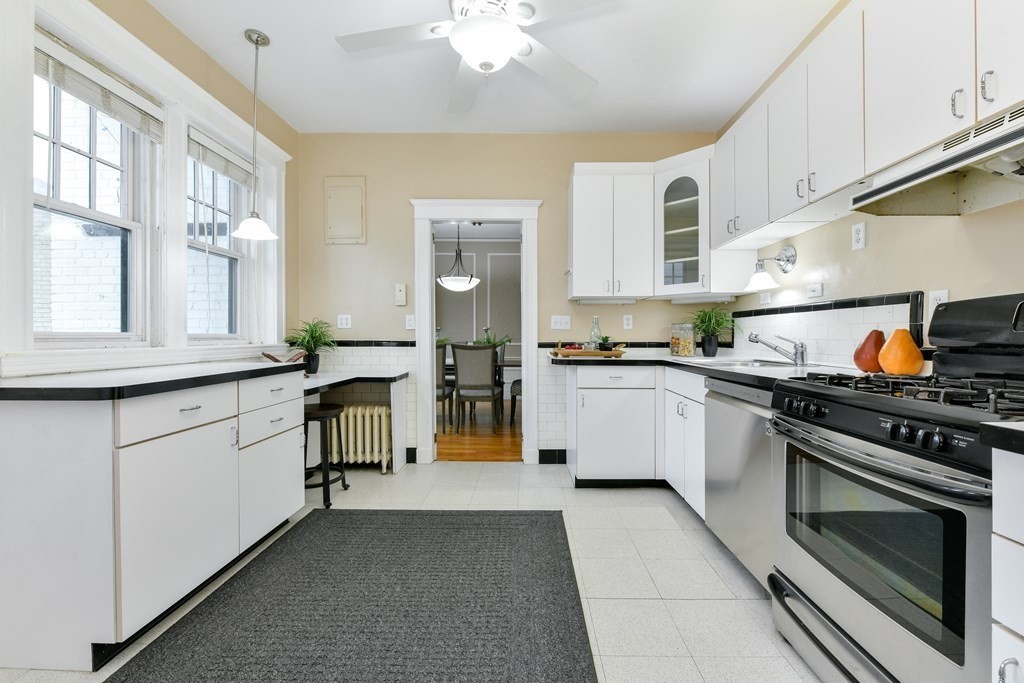 411 Washington Street, Unit 6 Brookline, MA 02446 - Photo 13 of 32 a kitchen with white cabinets and appliances