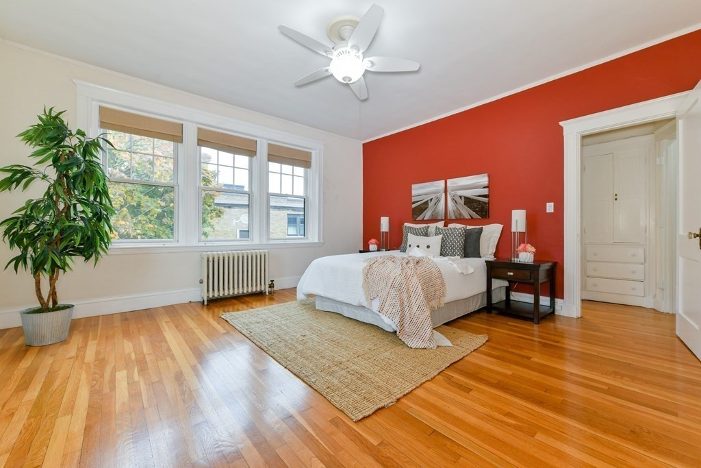 411 Washington Street, Unit 6 Brookline, MA 02446 - Photo 16 of 32 a bedroom with a bed and a large window with wooden floor