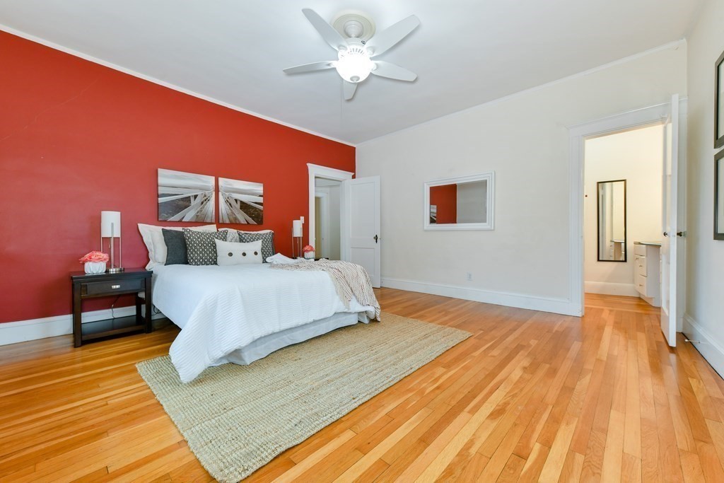 411 Washington Street, Unit 6 Brookline, MA 02446 - Photo 17 of 32 a bedroom with a bed and wooden floor