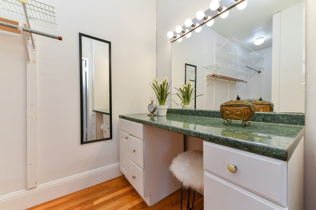 411 Washington Street, Unit 6 Brookline, MA 02446 - Photo 19 of 32 a kitchen with stainless steel appliances granite countertop a white cabinets and a chandelier