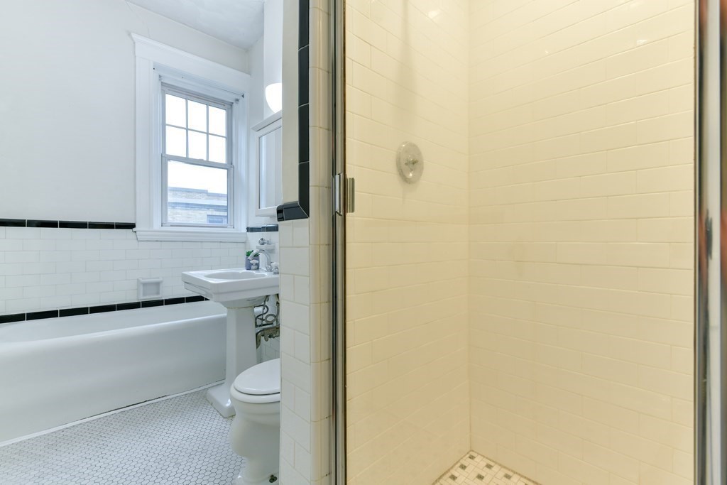 411 Washington Street, Unit 6 Brookline, MA 02446 - Photo 22 of 32 a bathroom with a toilet a sink and a window