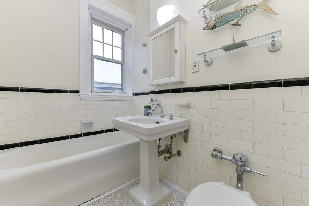 411 Washington Street, Unit 6 Brookline, MA 02446 - Photo 23 of 32 a bathroom with a sink a toilet and mirror