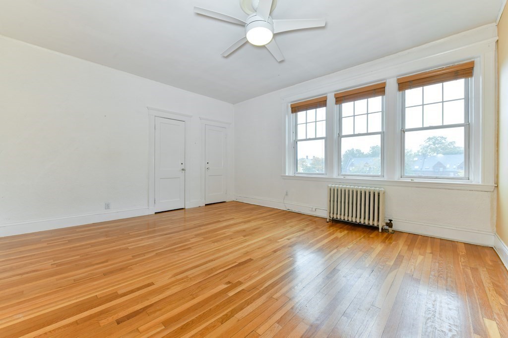 411 Washington Street, Unit 6 Brookline, MA 02446 - Photo 24 of 32 an empty room with wooden floor and windows