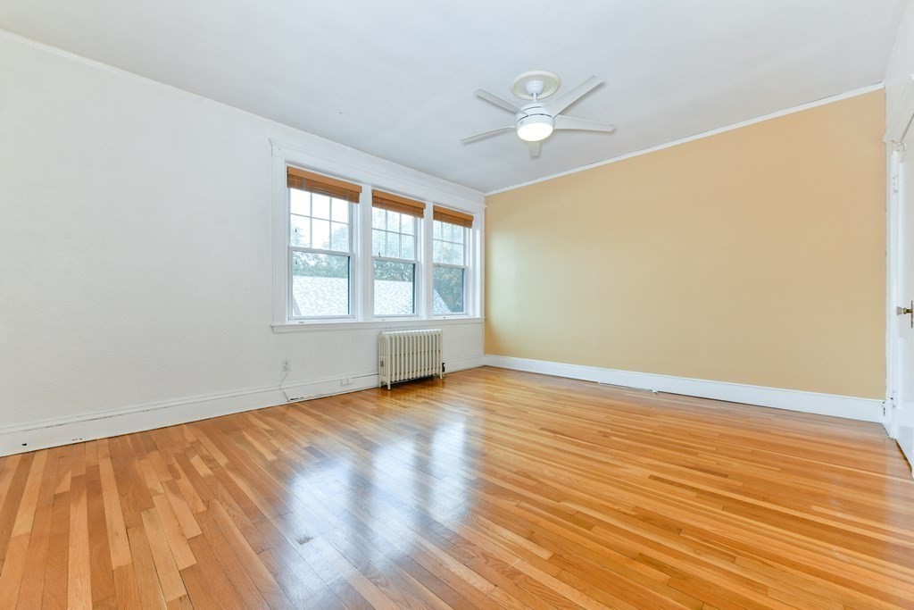 411 Washington Street, Unit 6 Brookline, MA 02446 - Photo 25 of 32 an empty room with wooden floor fan and windows