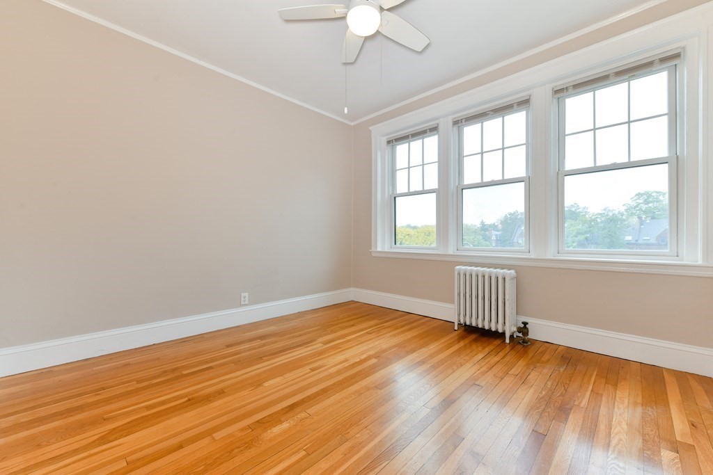 411 Washington Street, Unit 6 Brookline, MA 02446 - Photo 27 of 32 wooden floor in an empty room with a window