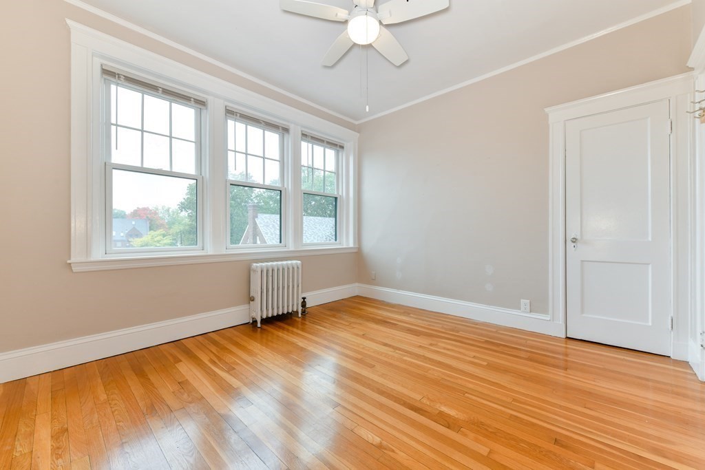411 Washington Street, Unit 6 Brookline, MA 02446 - Photo 28 of 32 a view of an empty room with wooden floor and a window