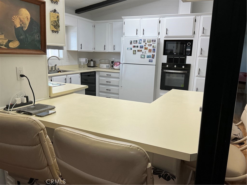 17625 Langlois Road, Unit SPACE 13 Desert Hot Springs, CA 92241 - Photo 19 of 47 a kitchen with a refrigerator a stove a sink and cabinets