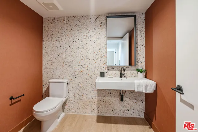 a bathroom with a sink a toilet and mirror